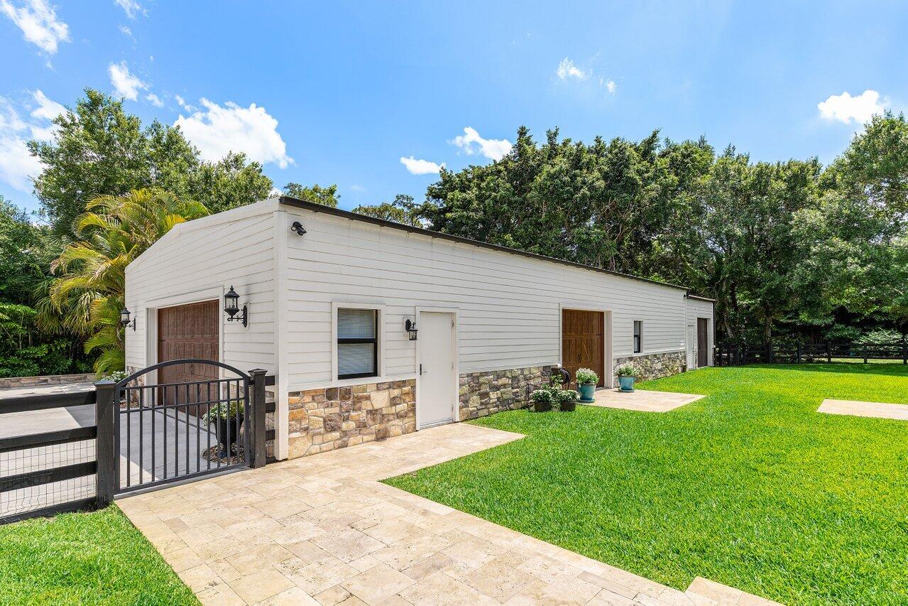 17270 Rocky Pines Road Jupiter, FL 33478 - Photo 31 of 69 a view of a backyard with plants and large trees