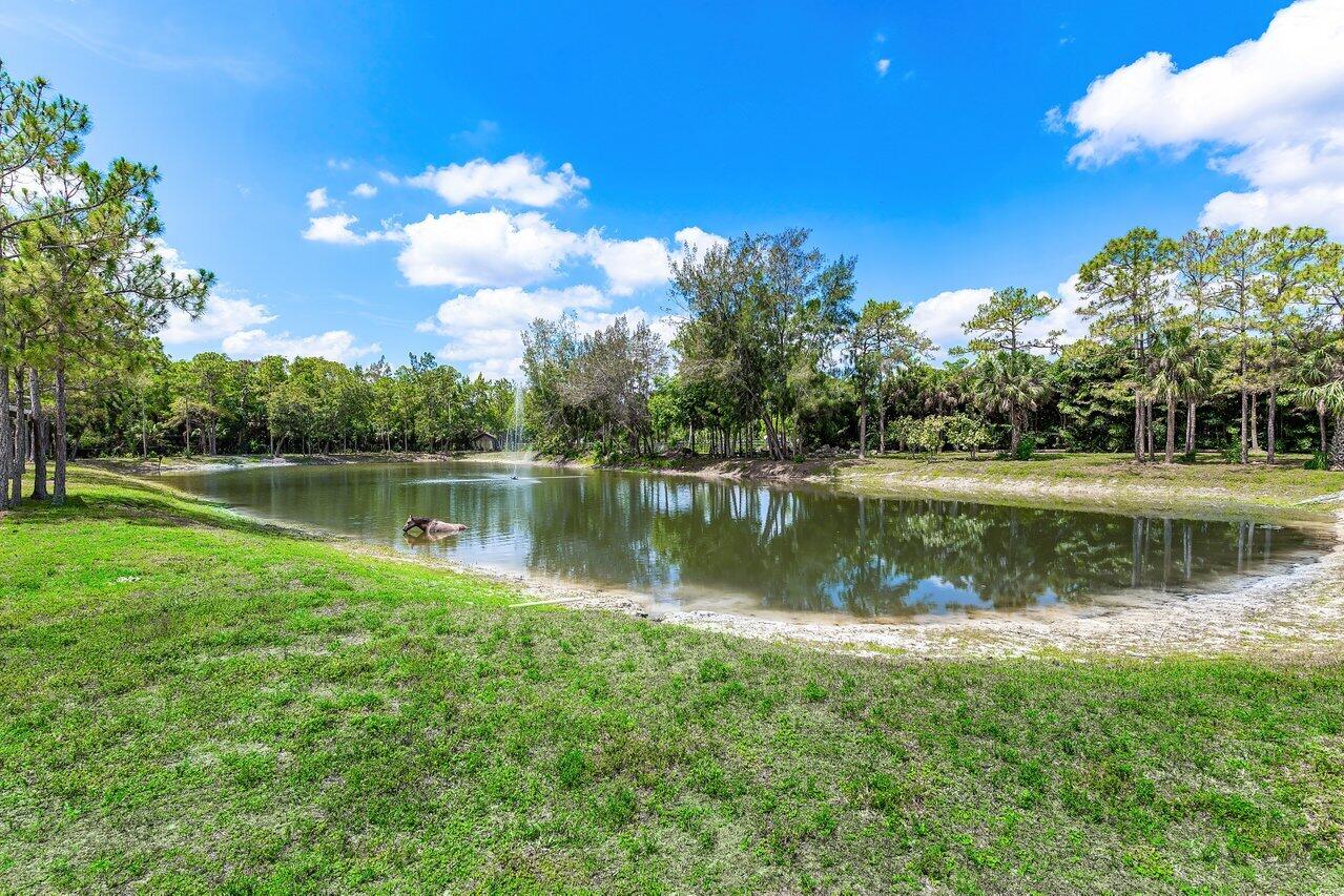 17270 Rocky Pines Road Jupiter, FL 33478 - Photo 39 of 69 a view of a lake with a house in the background