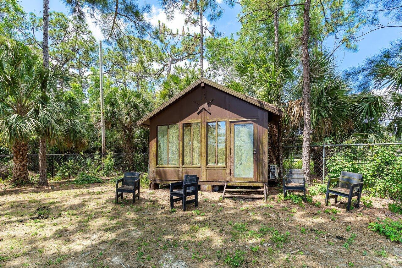 17270 Rocky Pines Road Jupiter, FL 33478 - Photo 42 of 69 a backyard of a house with table and chairs