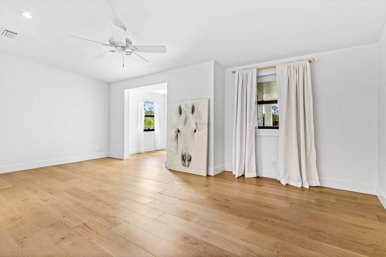 17270 Rocky Pines Road Jupiter, FL 33478 - Photo 51 of 69 a view of a livingroom with wooden floor and a ceiling fan