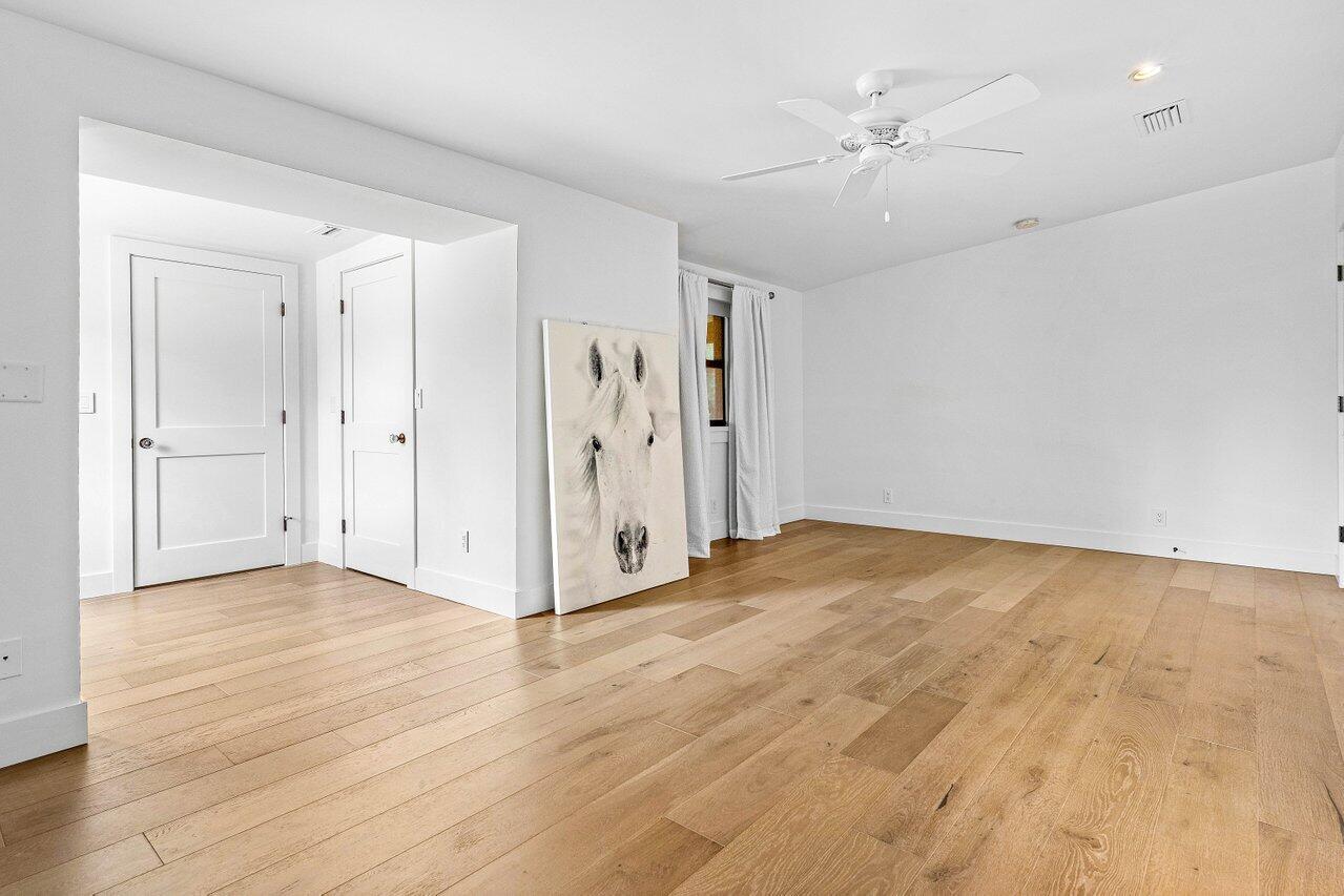 17270 Rocky Pines Road Jupiter, FL 33478 - Photo 52 of 69 an empty room with wooden floor and windows