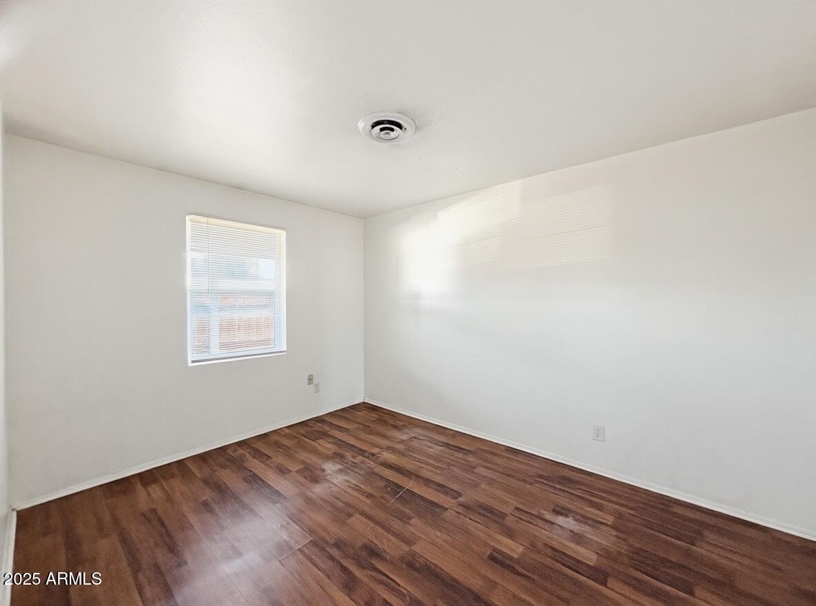 513 East Hatcher Road, Unit 9 Phoenix, AZ 85020 - Photo 9 of 10 an empty room with wooden floor and windows