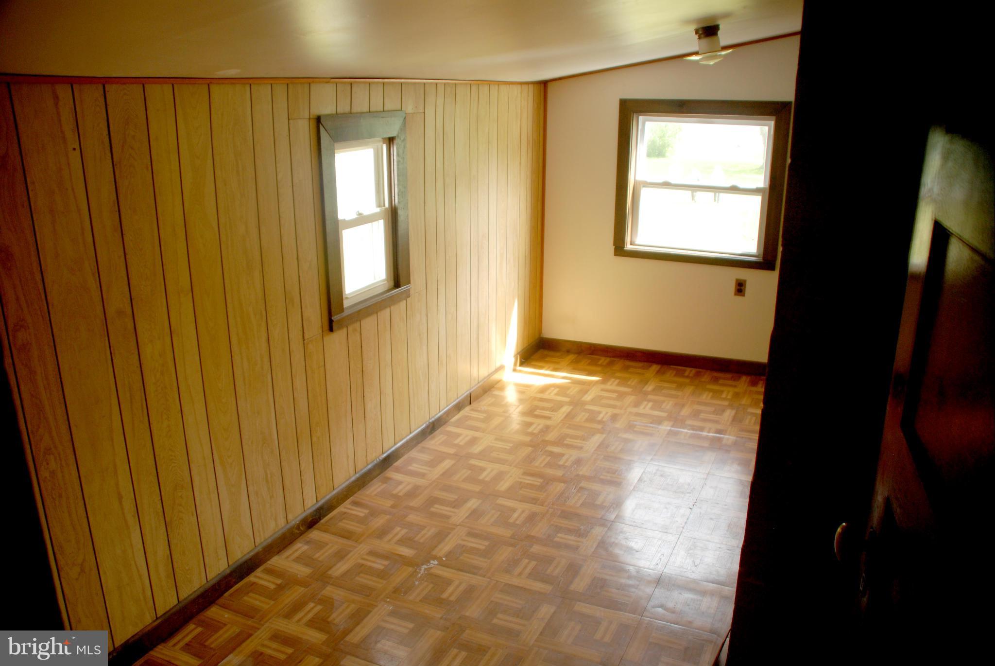 16484 Piney Point Road Piney Point, MD 20674 - Photo 22 of 28 a view of an empty room with wooden floor and a window