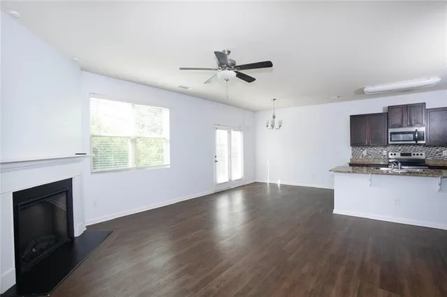 a view of kitchen with microwave a stove and wooden floor