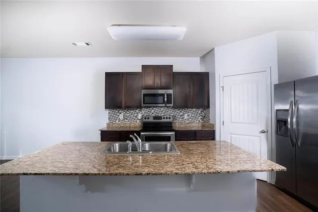 a kitchen with kitchen island a counter top space stainless steel appliances and cabinets