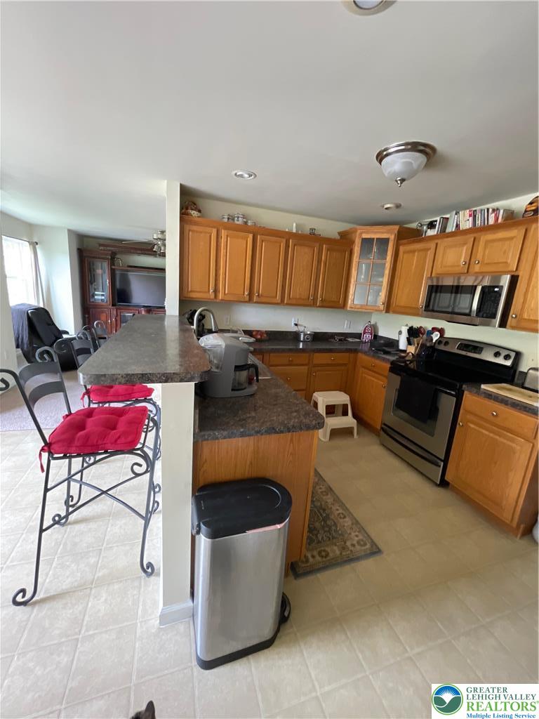 707 Gilbert Road Gilbert, PA 18331 - Photo 17 of 56 a kitchen with a stove a kitchen island a stove and a refrigerator
