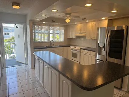 a kitchen with stainless steel appliances granite countertop a sink a stove and a refrigerator
