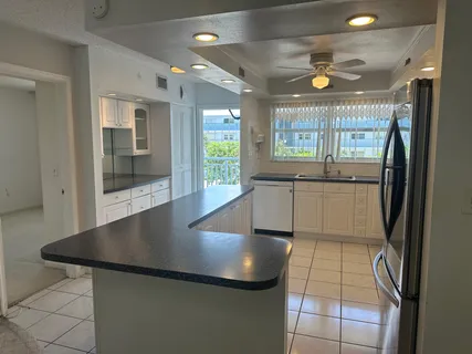 a view of a kitchen with a sink and large window