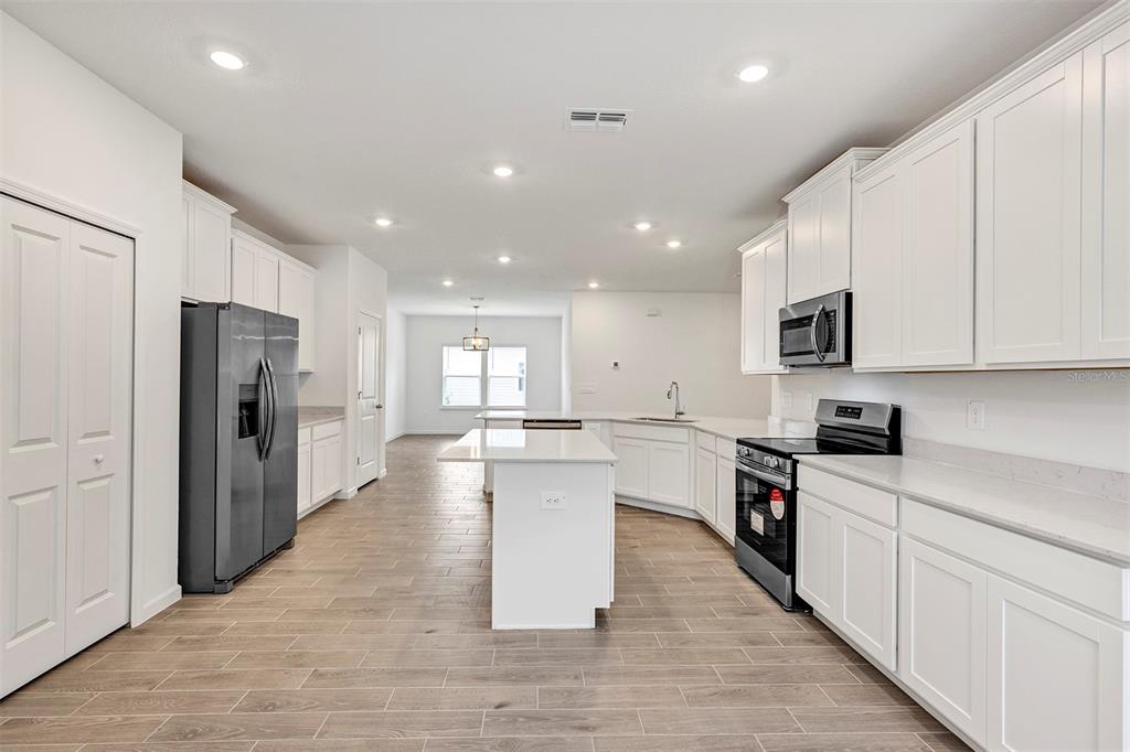 19438 Southwest 79th Street Dunnellon, FL 34432 - Photo 8 of 34 a large kitchen with stainless steel appliances lots of counter space and wooden floor