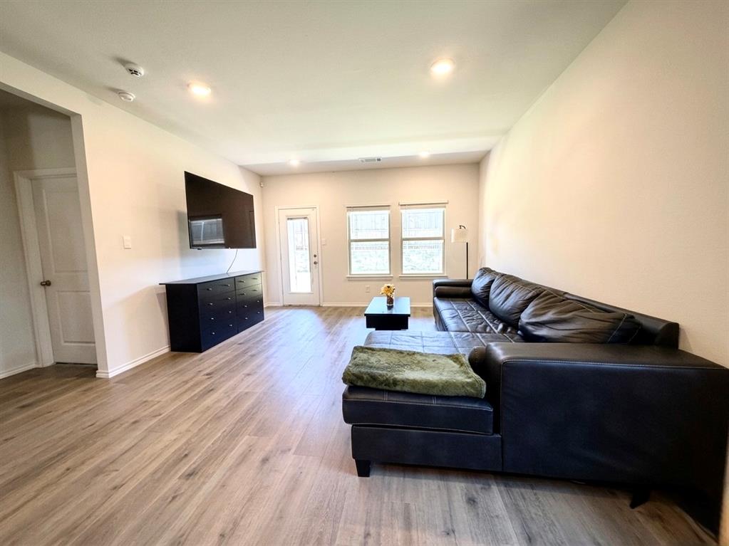 816 Country Road Royse City, TX 75189 - Photo 4 of 24 Spacious living area featuring light wood-finish flooring, recessed lighting, and ample natural light from multiple windows