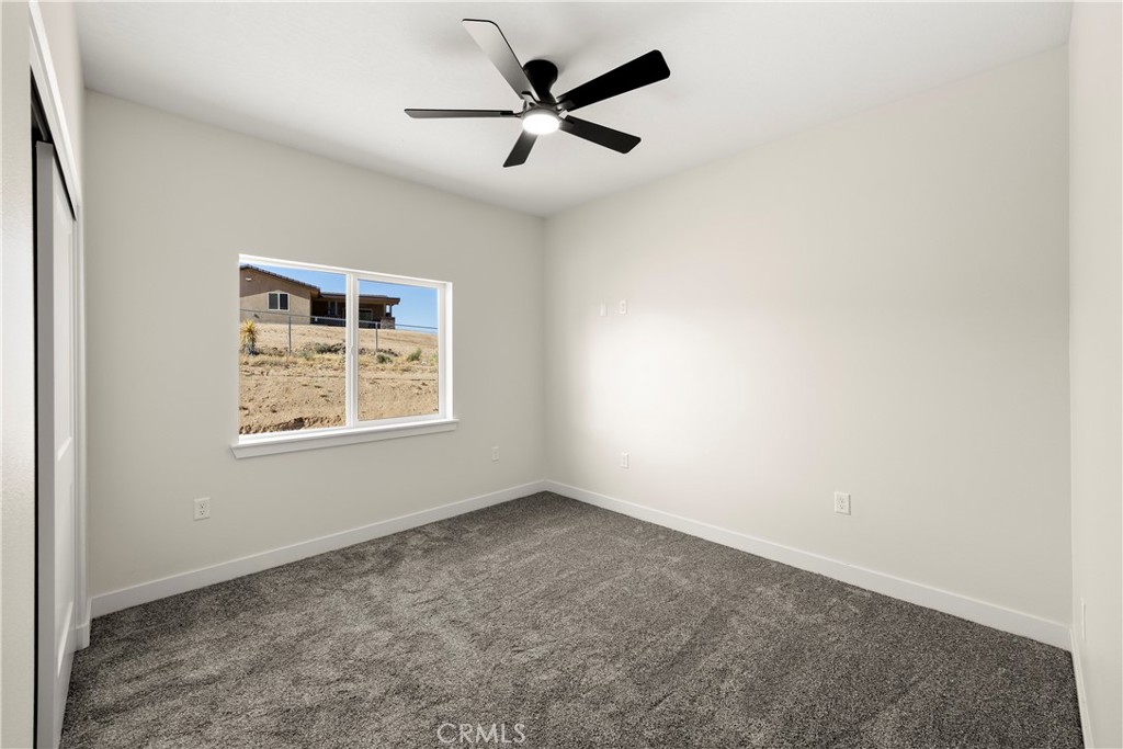 22324 Rancho Street Apple Valley, CA 92308 - Photo 35 of 47 an empty room with a window and a ceiling fan