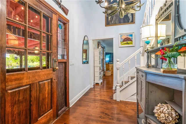 a kitchen with stainless steel appliances a stove a sink dishwasher a refrigerator and white cabinets with wooden floor