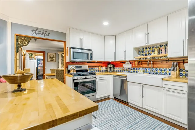 a kitchen with stainless steel appliances granite countertop a refrigerator a stove and a sink with cabinets