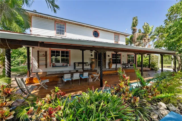 a living room with patio furniture and a potted plant