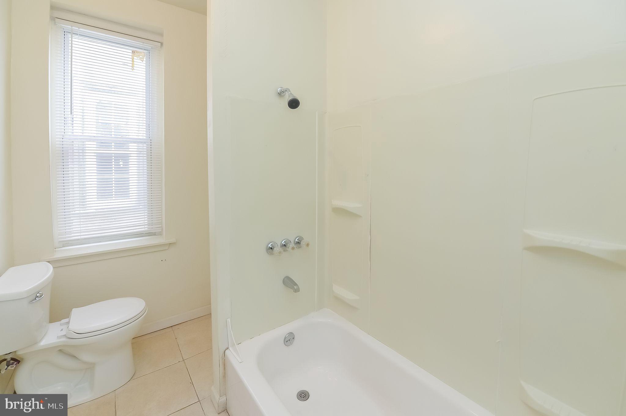3733 North 15th Street, Unit 2 Philadelphia, PA 19140 - Photo 10 of 12 a bathroom with a bathtub and window