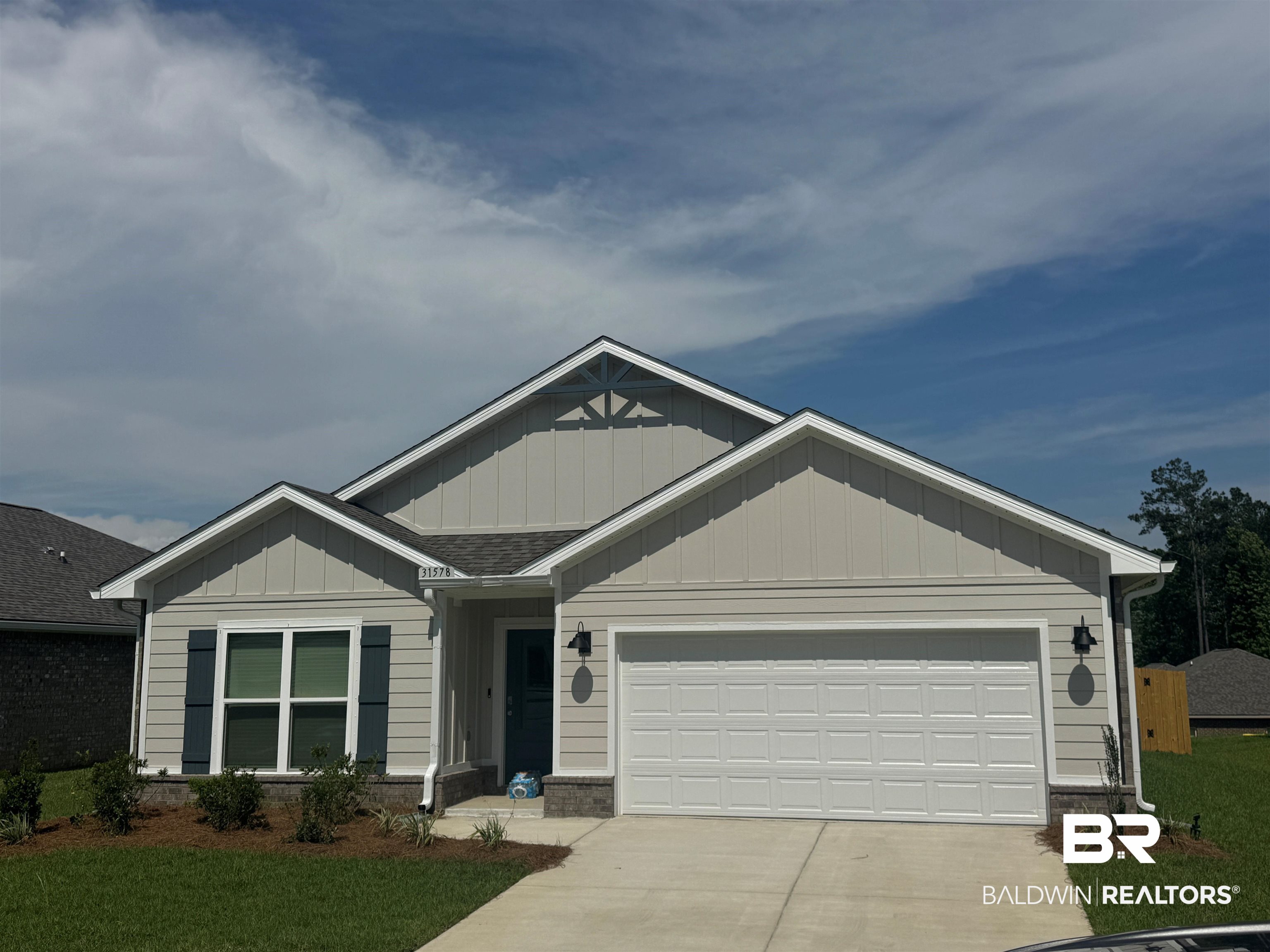 31578 Lyon Road Daphne, AL 36527 - Photo 1 of 33 Light gray siding exterior with dark blue shutters, a dark blue front door, and a white garage door