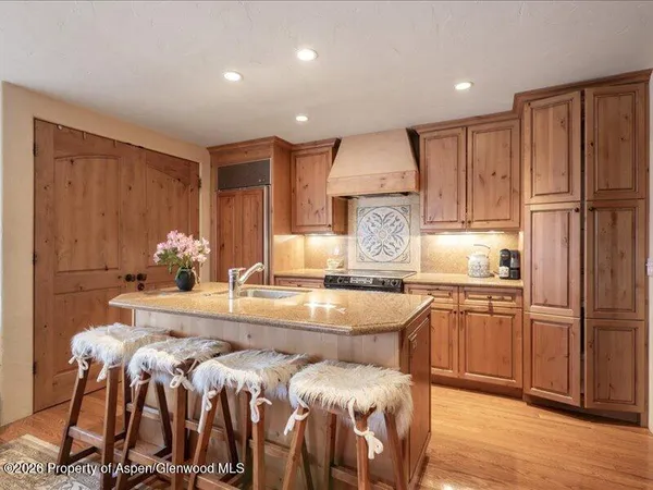 a kitchen with granite countertop a sink appliances cabinets and wooden floor