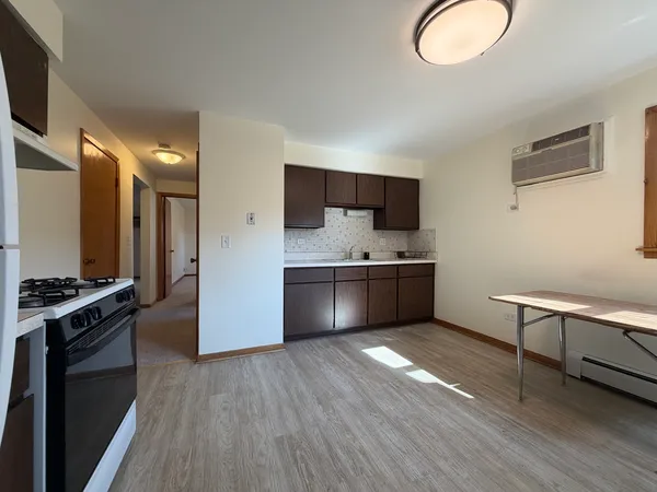 a kitchen with stainless steel appliances a stove a sink a refrigerator and a wooden floor