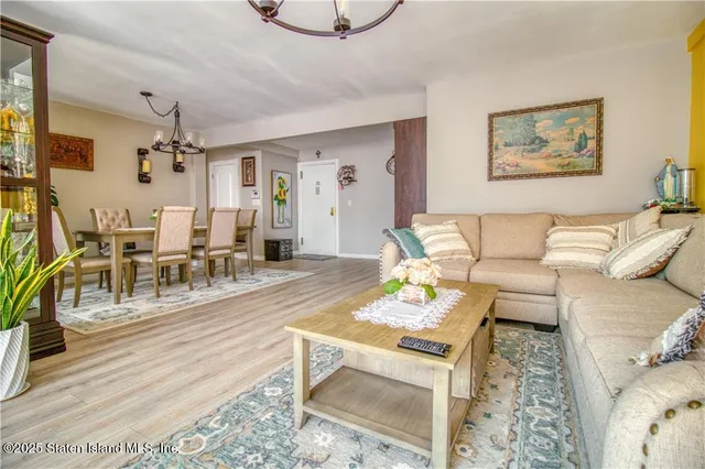 a living room with furniture and a chandelier