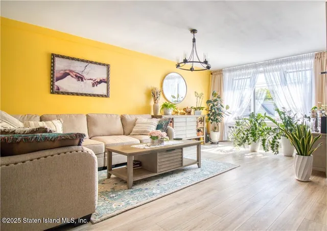 a living room with furniture a table and a chandelier