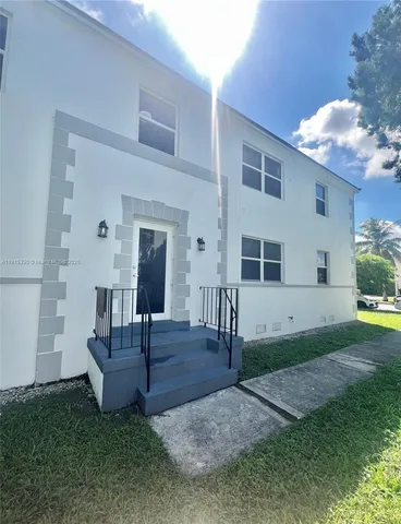 a view of a house with backyard and a tree