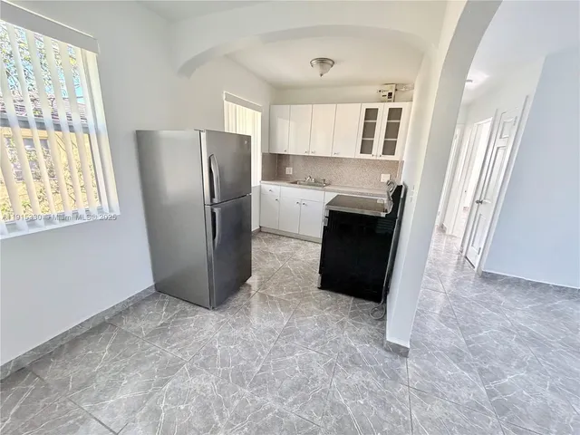 a view of a kitchen with furniture and a refrigerator