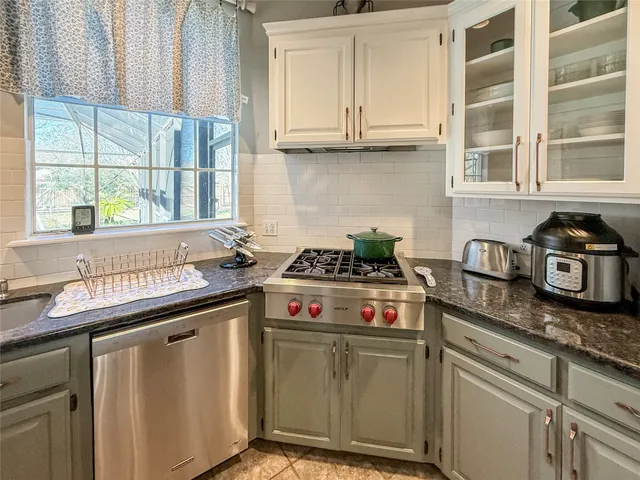 a kitchen with stainless steel appliances granite countertop a sink and a stove
