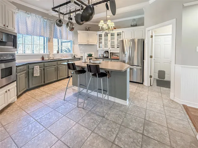 a kitchen with stainless steel appliances a sink a counter top space cabinets and a window
