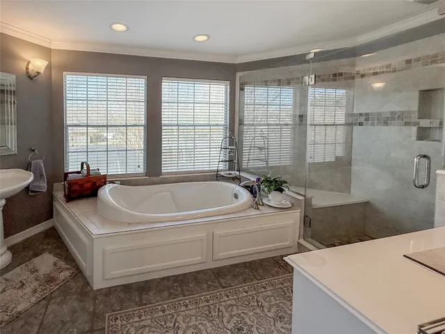 a spacious bathroom with a tub sink and shower