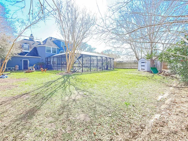 a view of a house with a yard and a large tree