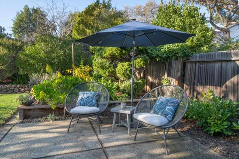 a backyard view with a seating space