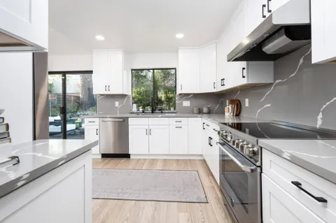 a kitchen with a sink a stove and cabinets