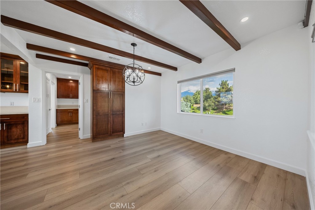 12646 10th Street Yucaipa, CA 92399 - Photo 18 of 72 an empty room with wooden floor a fireplace and windows