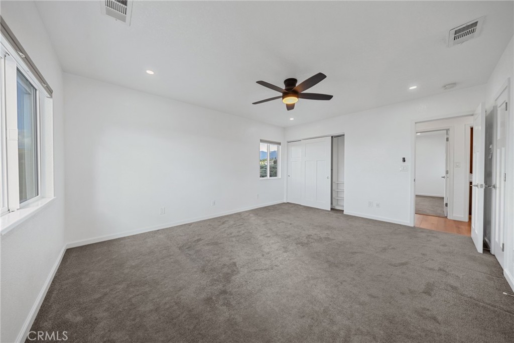 12646 10th Street Yucaipa, CA 92399 - Photo 26 of 72 an empty room with windows and a ceiling fan