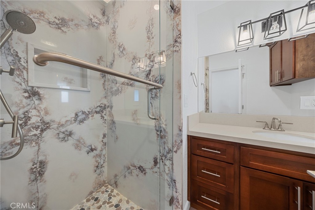 12646 10th Street Yucaipa, CA 92399 - Photo 34 of 72 a bathroom with a granite countertop sink a mirror and shower