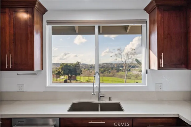 an empty room with wooden floor a fireplace and windows