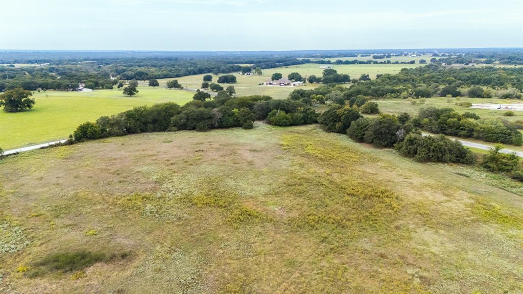 an aerial view of residential houses with outdoor space and trees