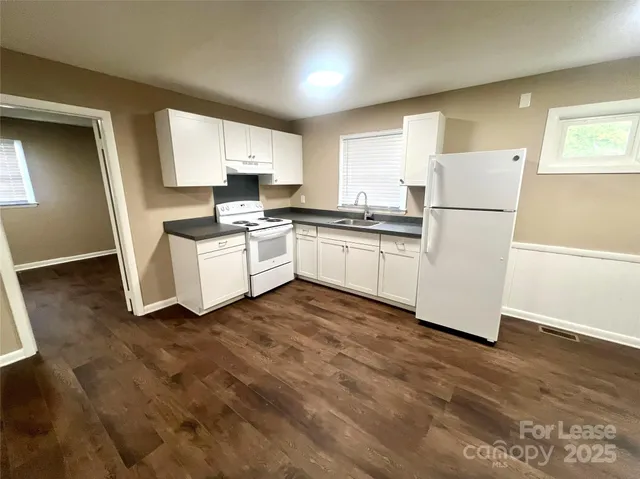 a kitchen with white cabinets and white appliances