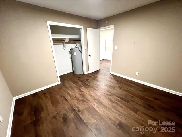 a view of a room with wooden floor and a window