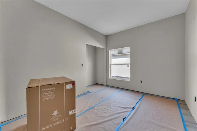 a view of an empty room with closet and a window