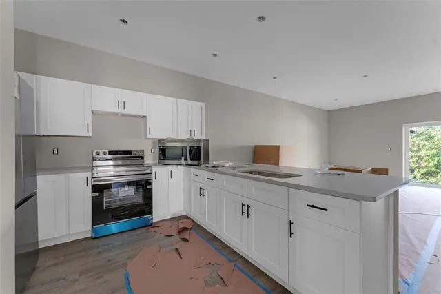 a kitchen with appliances a sink and cabinets