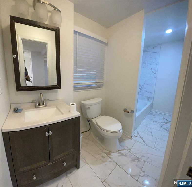 60 Passaic Street Garfield, NJ 07026 - Photo 12 of 14 a bathroom with a toilet sink and mirror