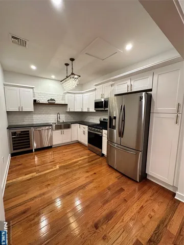 a kitchen with stainless steel appliances a refrigerator and a stove top oven