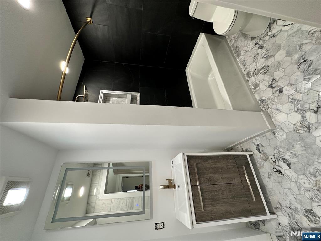 60 Passaic Street Garfield, NJ 07026 - Photo 6 of 14 a bathroom with a sink a toilet and shower