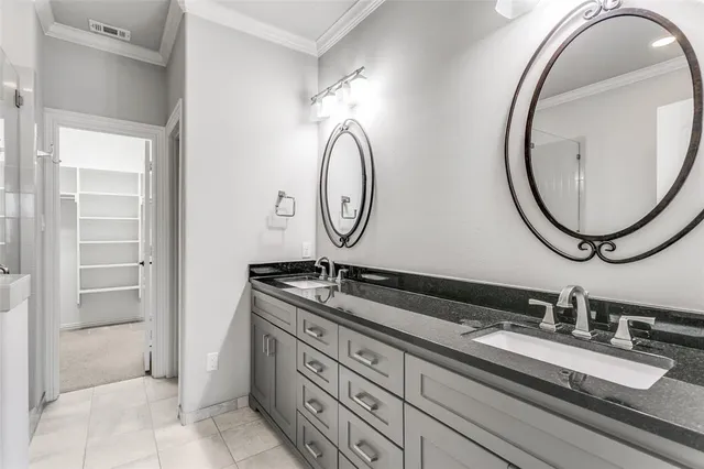 a bathroom with a granite countertop double vanity sink and a mirror