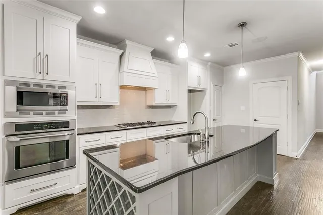 a kitchen that has a sink a stove and a microwave