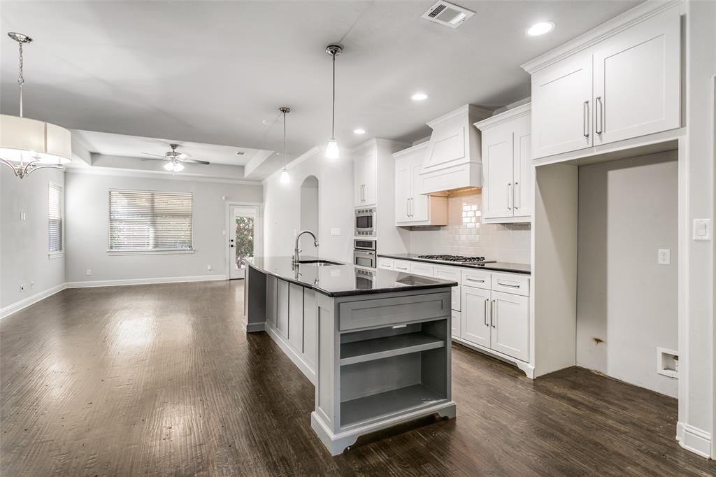 2221 Churchill Loop Grapevine, TX 76051 - Photo 8 of 26 a kitchen with stainless steel appliances granite countertop a stove a refrigerator and a wooden floors