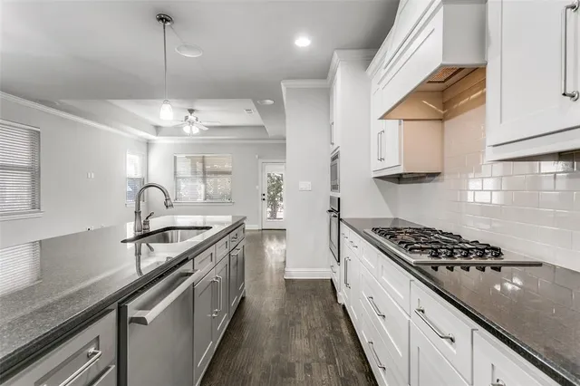 a kitchen with stainless steel appliances granite countertop a sink stove and cabinets