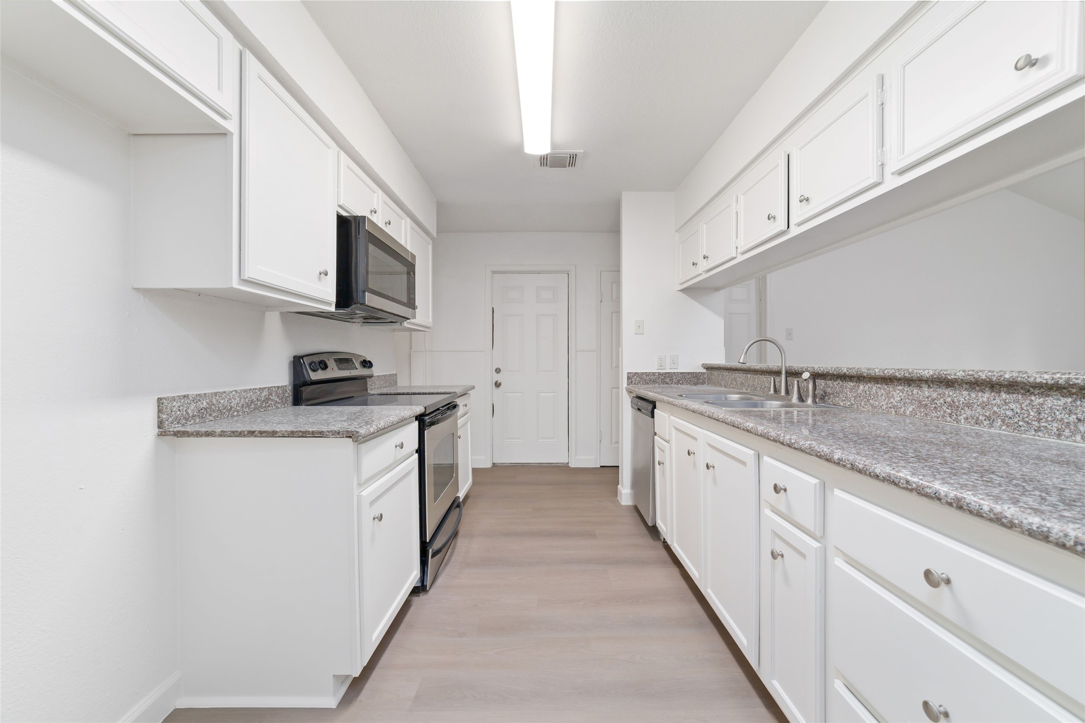 5023 Monteith Drive Spring, TX 77373 - Photo 8 of 20 Long, open kitchen layout with generous counter space and cabinetry, flowing easily toward the back of the home for a functional and connected feel.