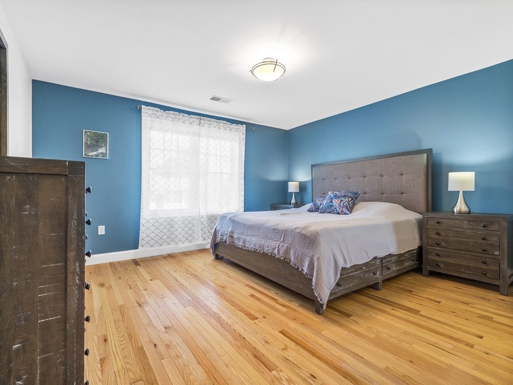 38 Webster Street, Unit 1 Needham, MA 02494 - Photo 12 of 35 a bedroom with a bed and wooden floor